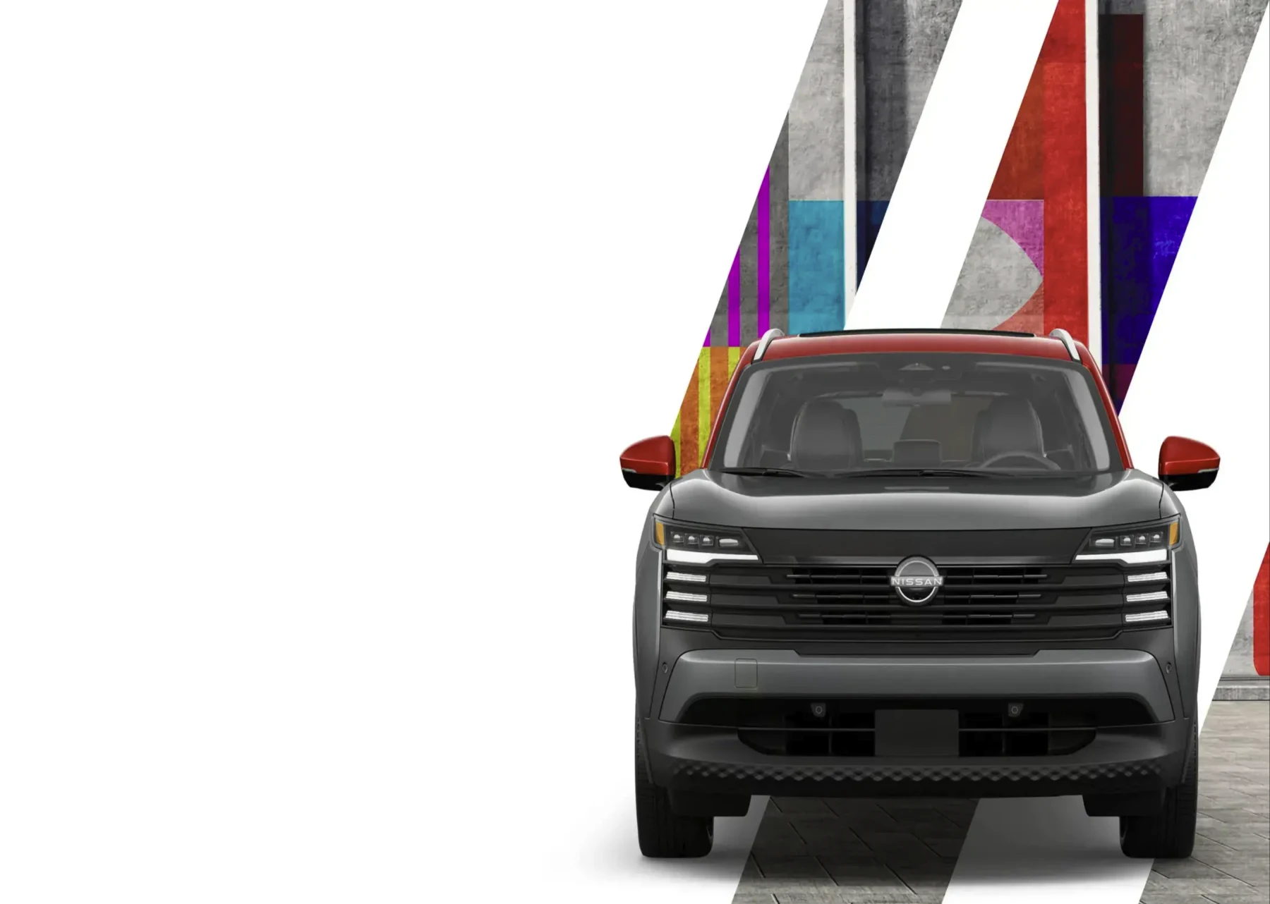 Nissan Kicks 2026 gris con techo rojo frente a un mural geométrico